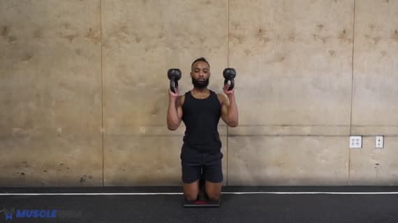 Kettlebell in ginocchio con pressa sopra la testa in posizione invertita