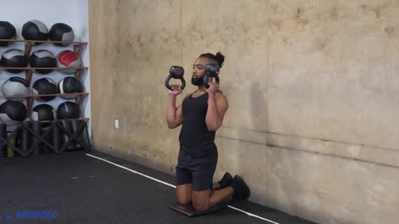 Kettlebell in ginocchio con pressa sopra la testa in posizione invertita